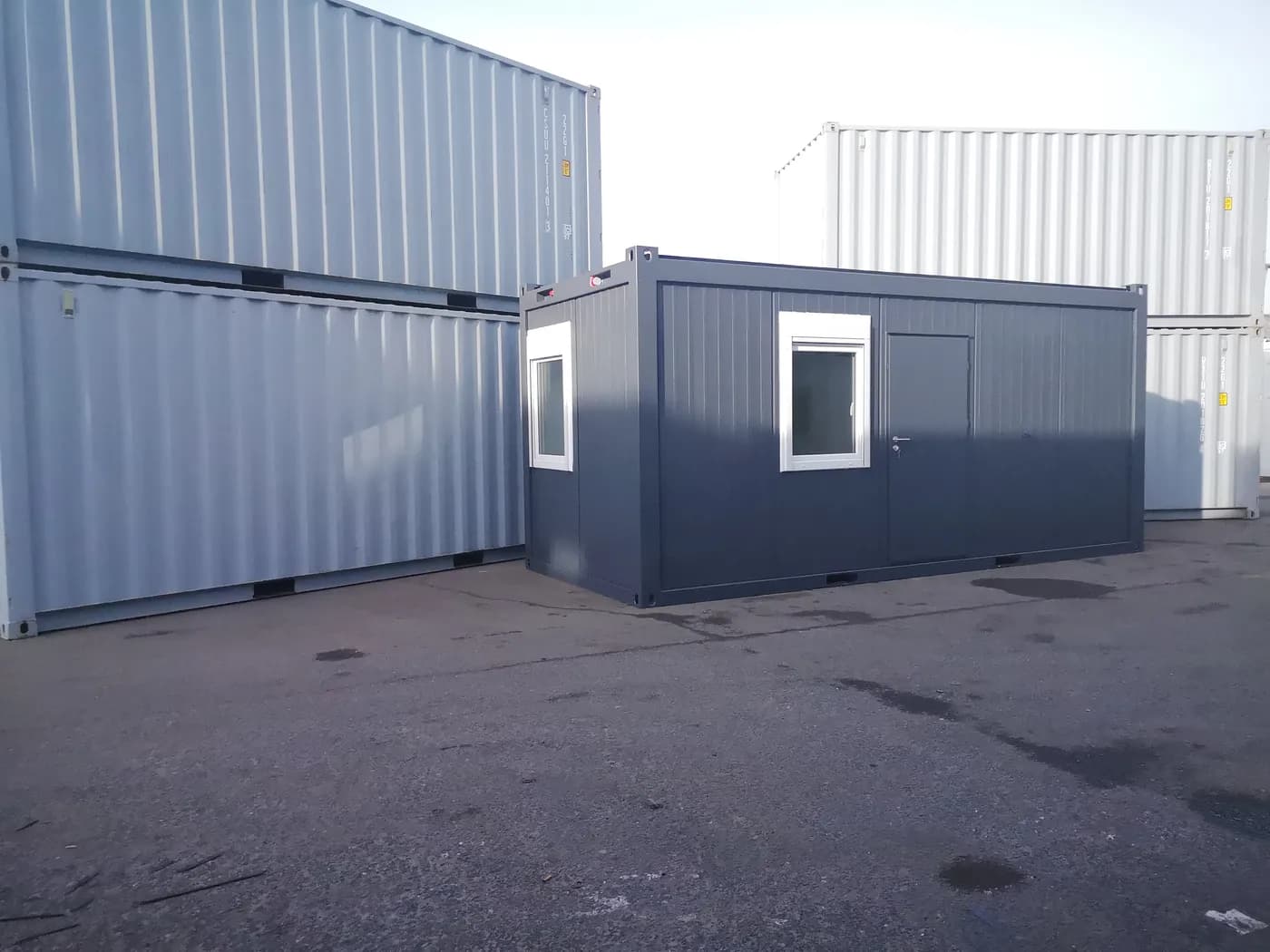 Mobiler Personalcontainer in dunkelblauer Ausführung mit Fenster und Tür – ideal als temporäres Büro oder Aufenthaltsraum auf Baustellen oder Events.